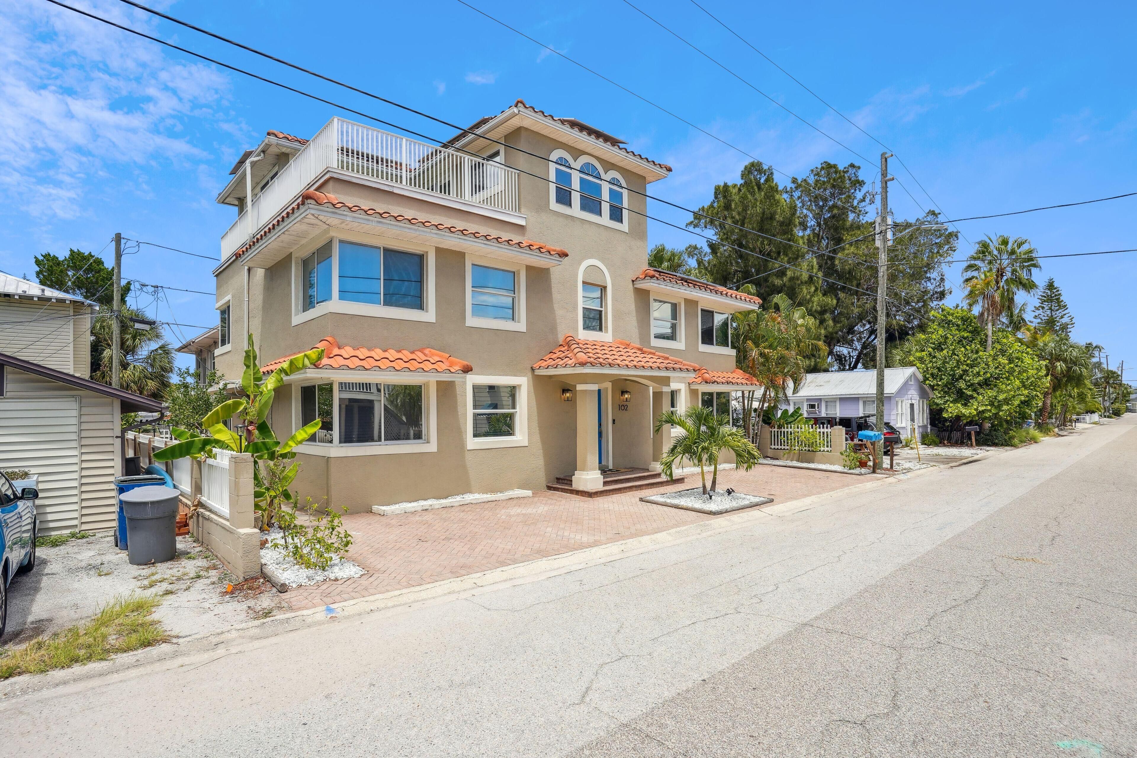 A two-story house with a balcony, a garage, and a driveway.
