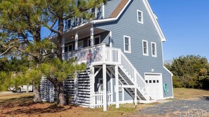 A two-story house with a porch and a staircase leading to the second floor.