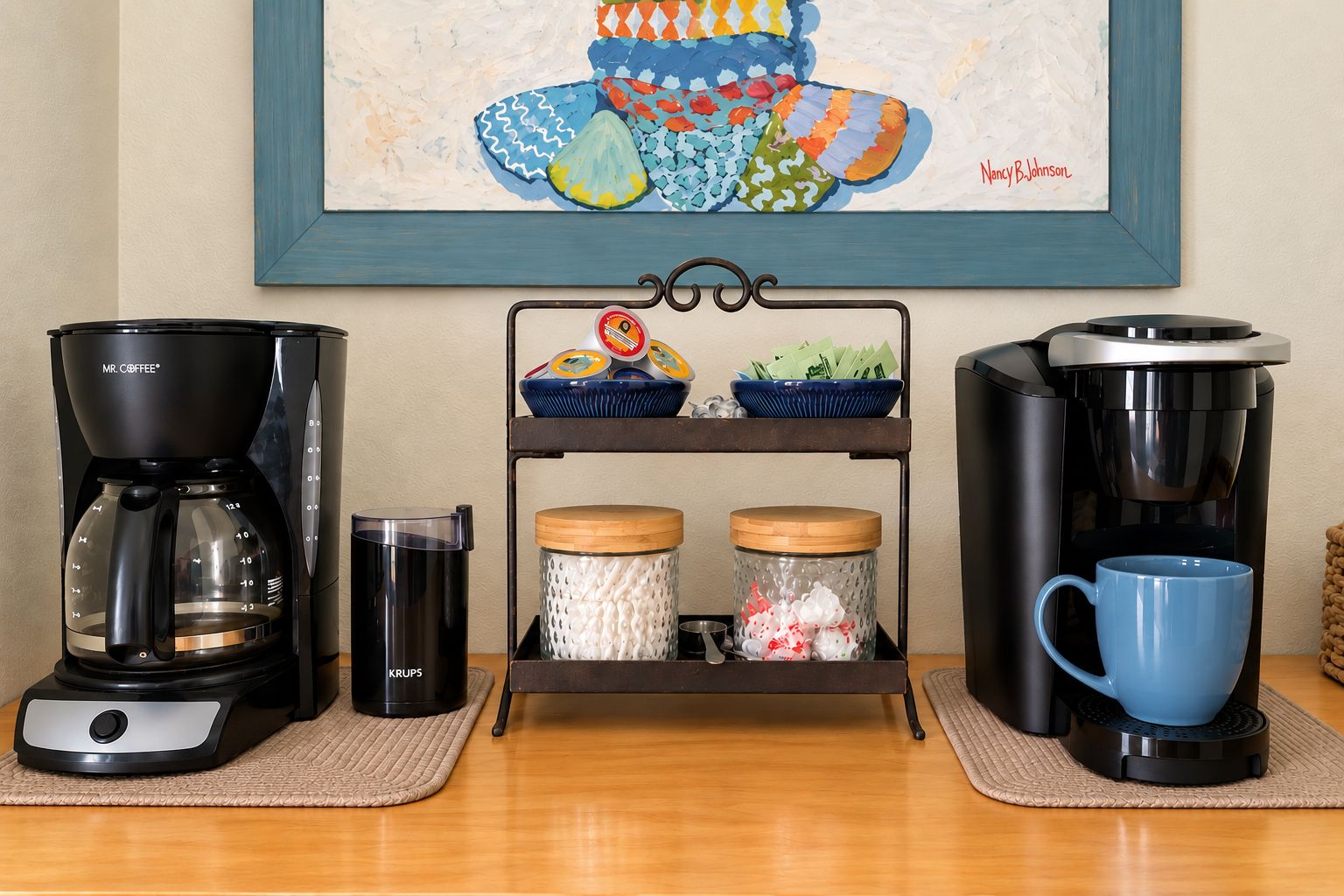 A coffee station with two coffee makers, a mug, and a tray with containers.