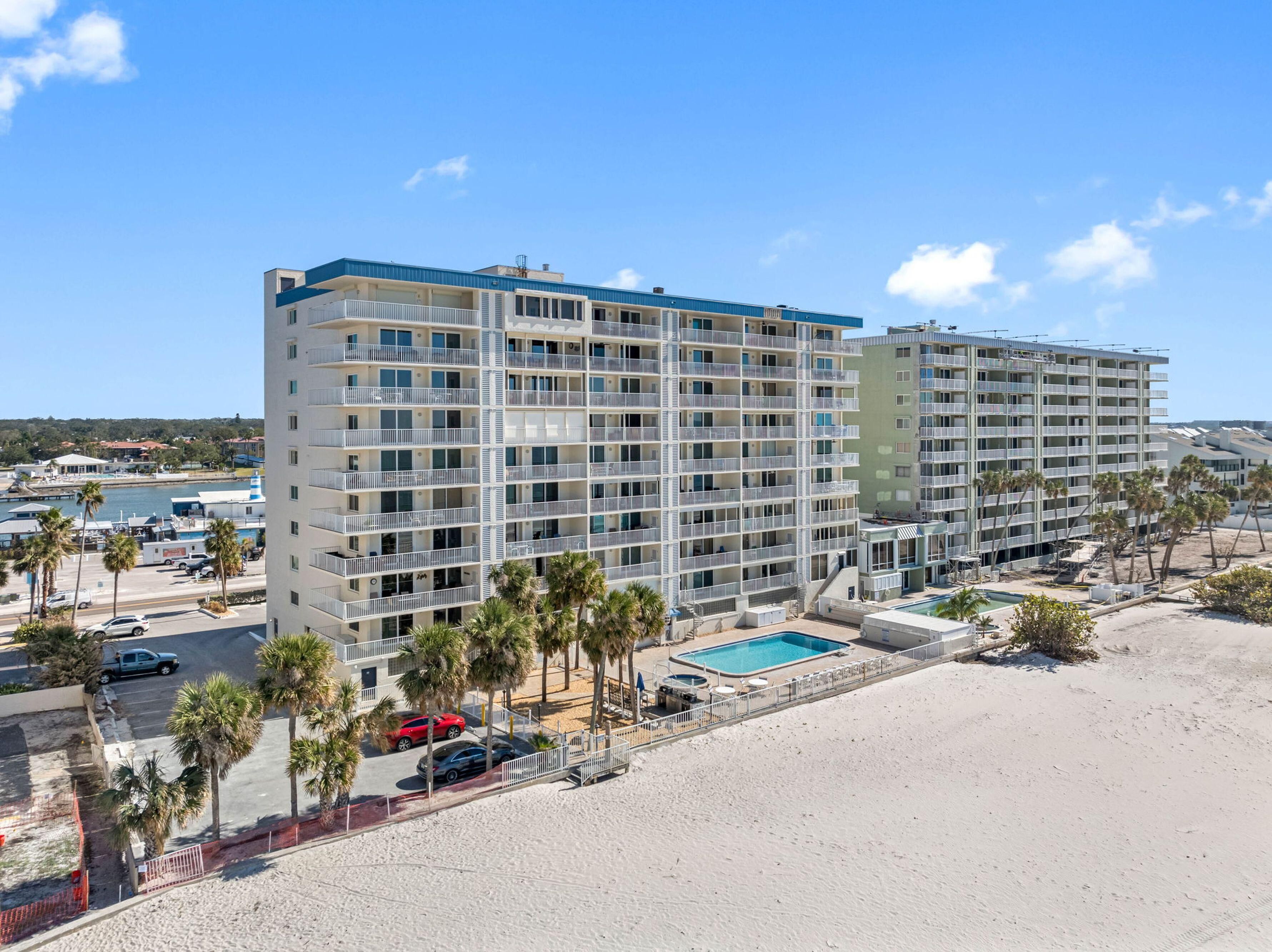 Un hôtel à plusieurs étages doté de balcons, d’une piscine et offrant une vue sur la plage.