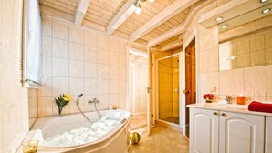 A modern bathroom with a freestanding bathtub, a walk-in shower, and a vanity with a mirror.