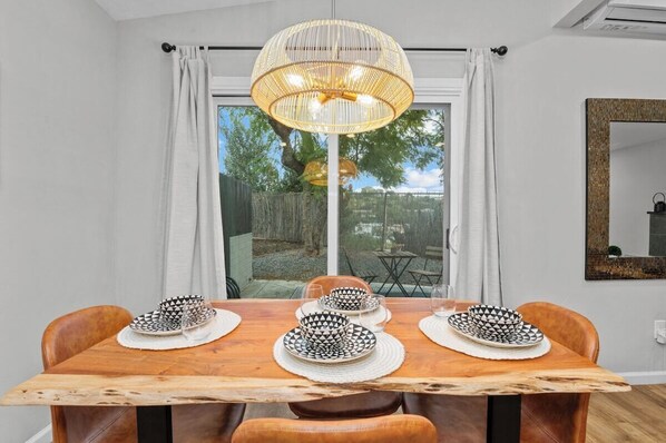 Enjoy meals in this stylish dining area with a table for four, a pendant light, and a view of the outdoors.