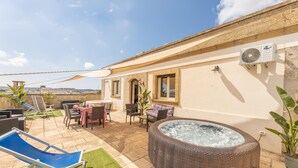 A patio area with a hot tub, outdoor seating, and a view of the city. - Palazzo Lily - Racale (Racale)