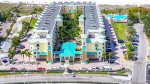 Un hotel con piscina central, varias plantas y vistas a la playa.
