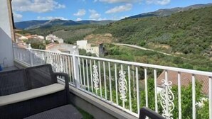 A balcony with a view of a mountainous landscape.
