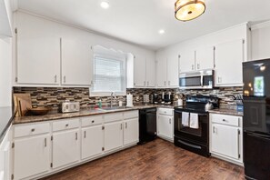 Een broodrooster, kookgerei, borden en bestek, kruiden