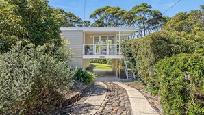 A two-story house with a covered porch and a stone pathway leading to the entrance. - Pipis Pretty Point - Couples Retreat (Malua Bay)