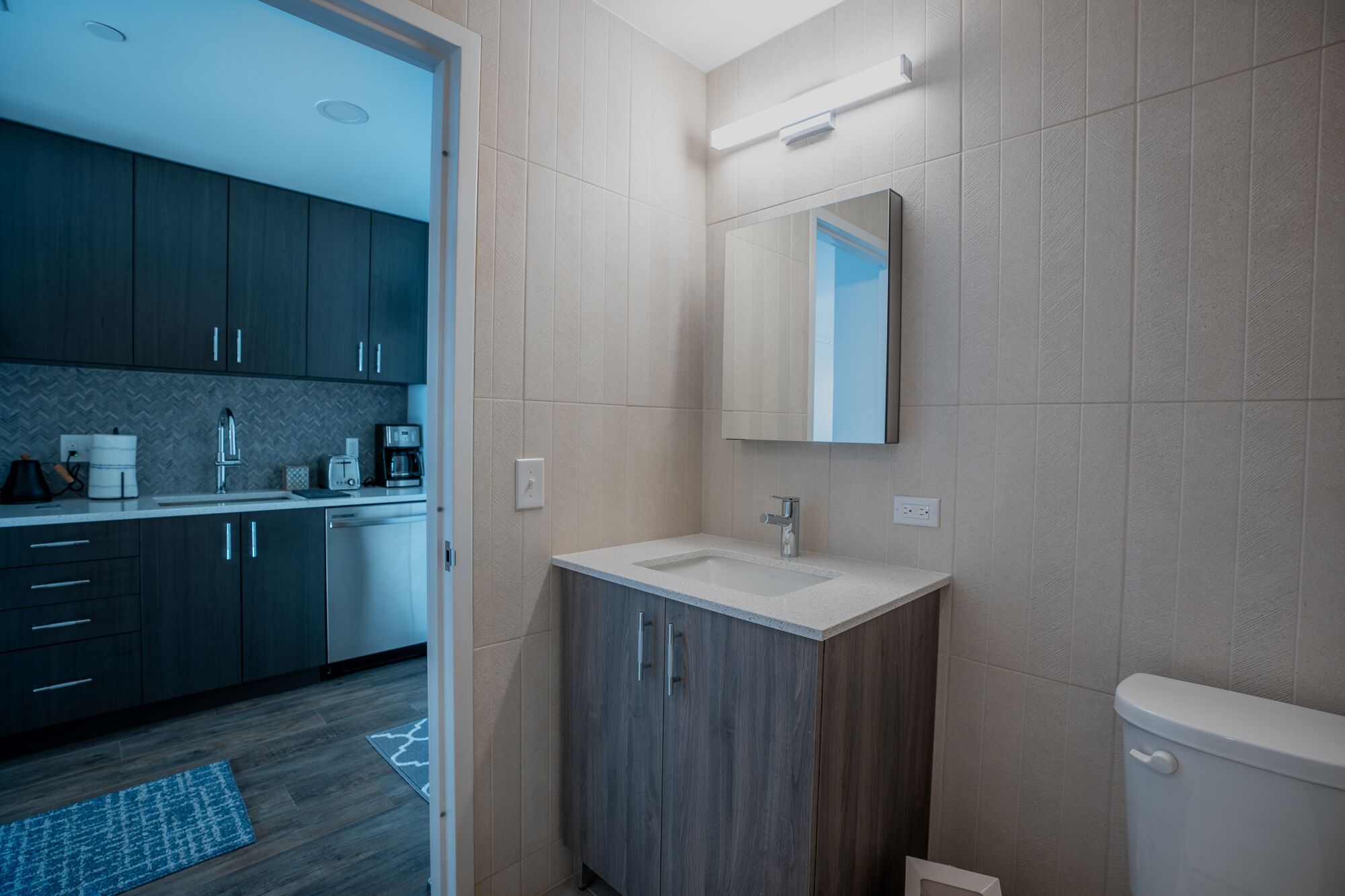Une salle de bain moderne avec un lavabo, un miroir et des toilettes.