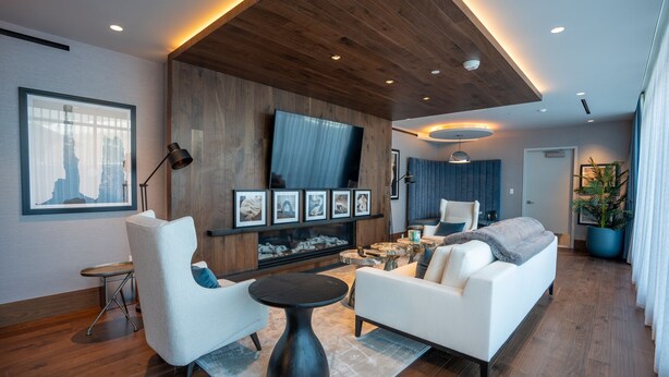 A modern living room with a fireplace, white sofas, a coffee table, and a TV mounted on the wall. - Pioche Village by Park City Vacations (Park City)