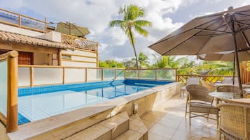 Una piscina al aire libre, sombrillas, tumbonas