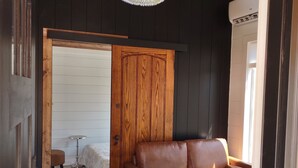 A modern interior with a leather sofa, a small round table, and a chandelier.