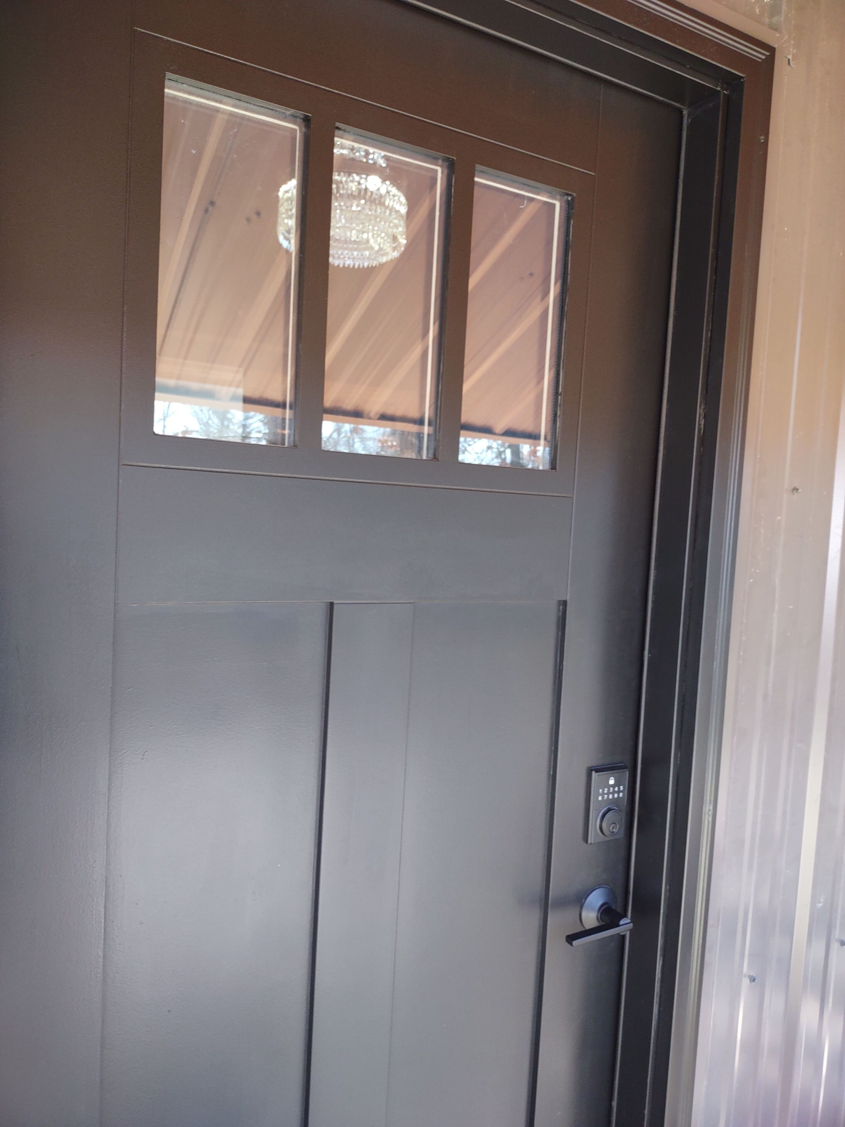 A door with a window and a keypad lock.