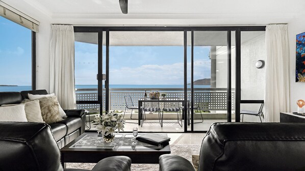 Relax in this ocean-view living room with a sofa, coffee table, and glass-top dining area.