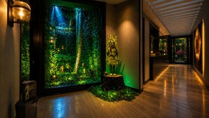 Un couloir avec un grand aquarium, une statue et un plancher en bois.