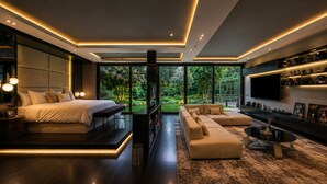 Une chambre moderne avec un grand lit, un canapé et un téléviseur.