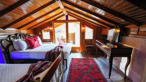 Acogedor dormitorio en el ático con cama, escritorio y televisor.