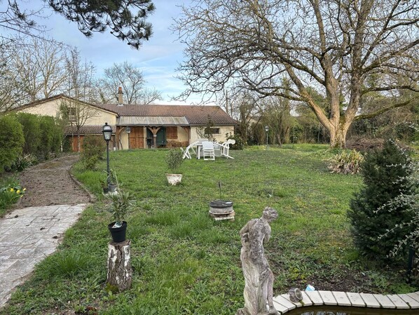 A house with a garden, a stone pathway, and a statue. - Agréable Maison de Ville Avec Tout à Proximité ! (Saint-Dizier)