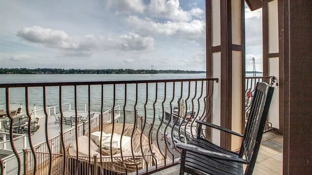 A balcony with a view of the water, a wooden deck, and a chair. - Lakefront with dock, close to April Sound Country Club. BBQ Grill, Laundry (Montgomery)