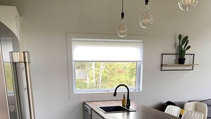 A modern kitchen with a large island, stainless steel appliances, and a window providing natural light.