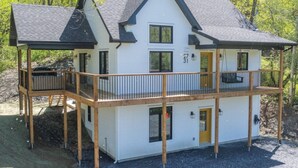 Une maison à deux étages avec un balcon, une terrasse et un garage.