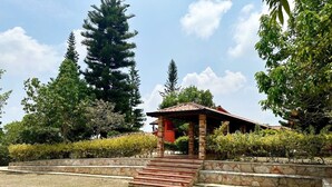 A gazebo with stone steps leading up to it, surrounded by a stone wall and greenery. - Hotel Cristo Rey Campestre (Los Santos)