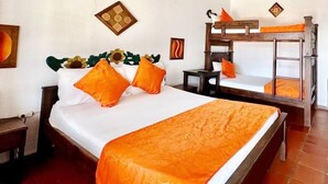 A room with a large bed, a smaller bed, a nightstand, a wooden bench, and a wall-mounted light fixture. - Hotel Cristo Rey Campestre (Los Santos)