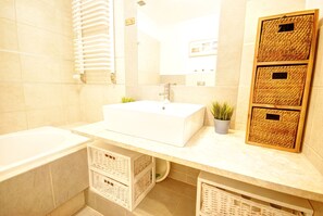 A bathroom with a white sink, a mirror, and three wicker baskets on the countertop. - HelApart - Helska Villa (Hel)