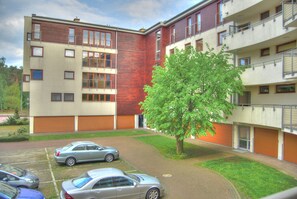 A multi-story residential building with a parking area and a tree in the courtyard. - HelApart - Helska Villa (Hel)