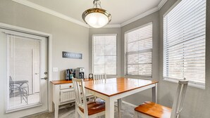 A dining area with a wooden table and four chairs, a coffee maker, and a sign that reads "Coffee Bar".