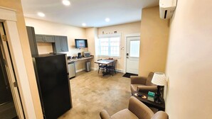 A compact living space with a kitchenette, a dining area, and a seating area with a lamp. - Breckenridge Suites #6 - Cozy 1-Bedroom Suite with Fully Equipped Kitchen (Grove City)