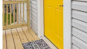 A house with a yellow front door, a mailbox, and a wooden deck. - Private Hudson Valley Escape (Kingston)