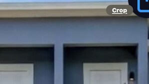 A two-story building with a grey facade, white doors, and a balcony with a railing. - The Rosezena Experience. (Palmetto)