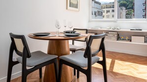 A dining area with a round wooden table, four chairs, and hanging pendant lights.