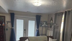 A living room with a brown sofa, a glass coffee table, and a ceiling with a textured finish. - Canyon View (Lewiston)