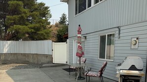 A residential backyard with a patio, a grill, and a white fence. - Canyon View (Lewiston)