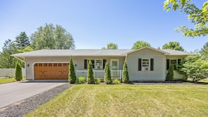 A single-story house with a garage, a front porch, and a well-maintained lawn. - Green Lawn (Grawn)