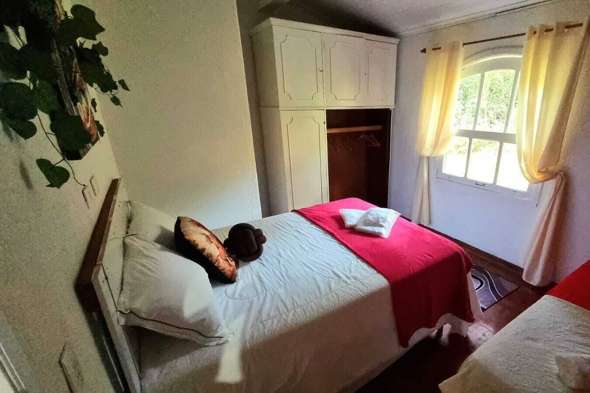 Un dormitorio con dos camas, un armario y una ventana con cortinas.
