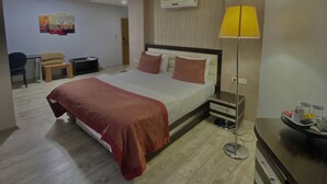 A modern hotel room with a bed, bedside table, lamp, and a desk with a chair. - Sivas Azze Palace Otel (Sivas)