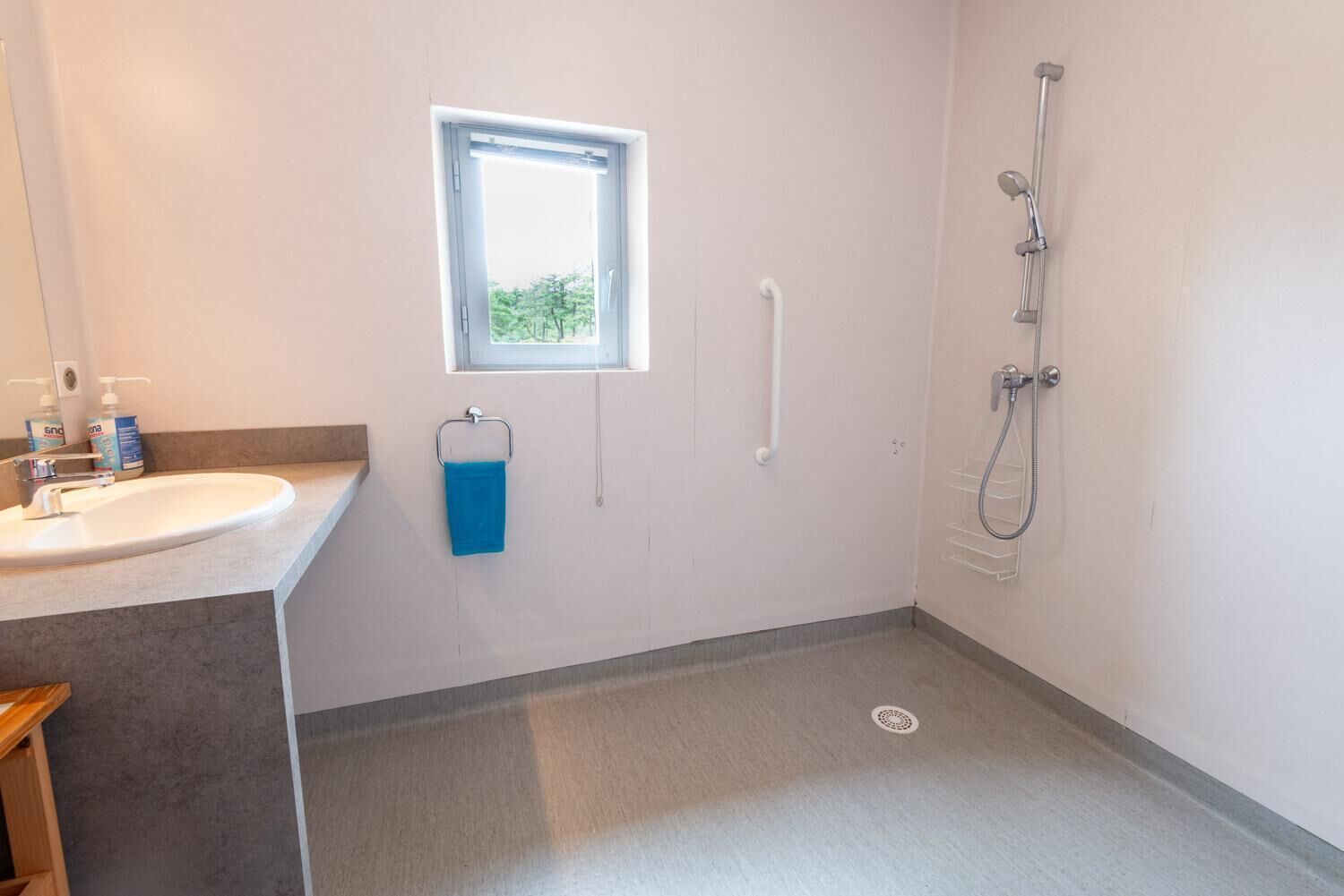 Un baño con lavabo, ventana y ducha.