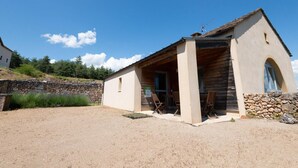 A small, single-story building with a stone wall and a wooden porch. - La Baumelle 4/6 persons (SAINT-PIERRE-DES-TRIPIERS)