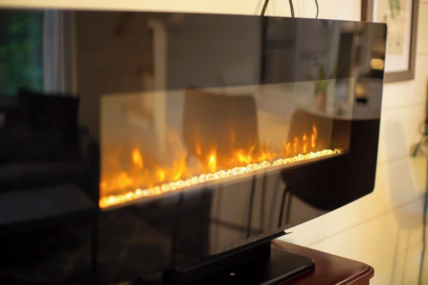 A flat-screen TV on a stand with a visible fire feature.