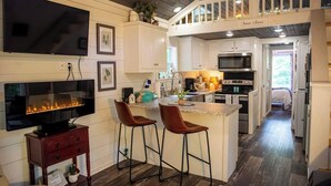 Una cocina moderna con una isla grande, taburetes de bar y una chimenea.