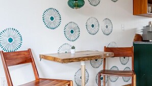Una habitación con dos sillas de madera, una mesa de madera y un muro decorado con diseños circulares.