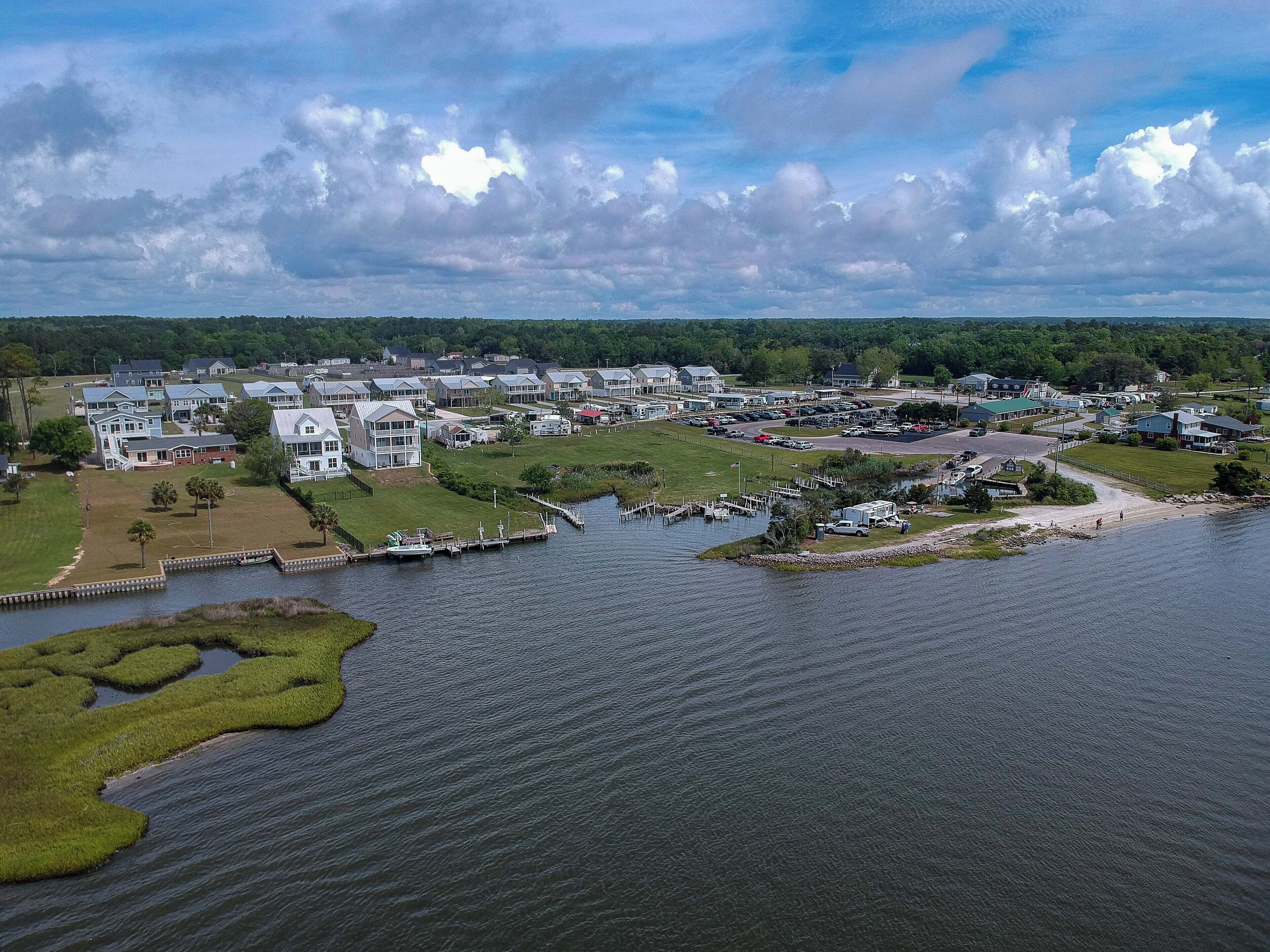 An aerial view of a lakeside community with residential buildings, docks, and a marina.