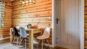 A wooden-paneled room with a wooden table and four chairs.