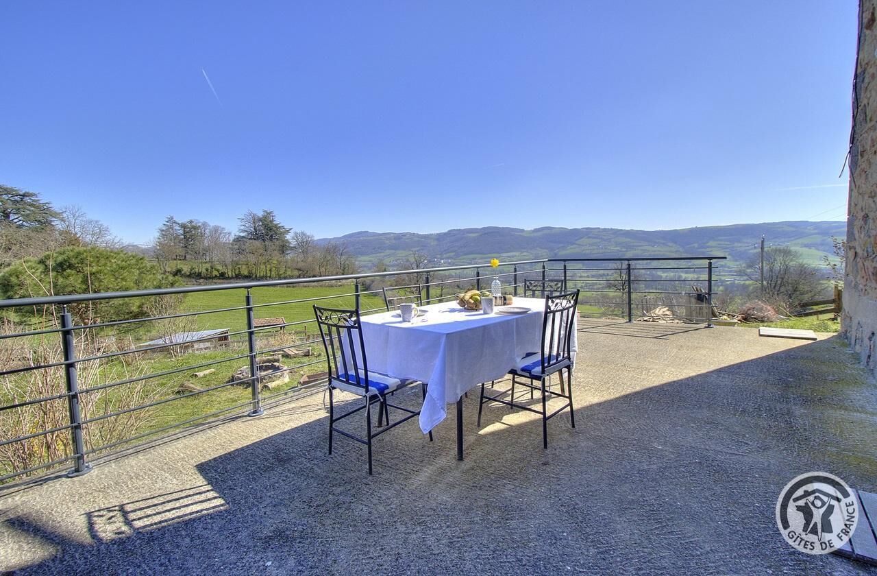 A table set outdoors with a view of hills.
