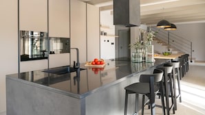 Una cocina moderna con una isla central, electrodomésticos de acero inoxidable y un diseño minimalista.