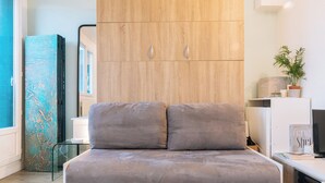 A modern bedroom with a bed, a wardrobe, a glass table, and a potted plant. - Stylish Studio 12 Min from Republique (Paris)
