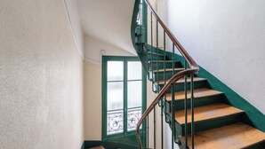 Eine Treppe mit Holzbalken und grünen Geländern.