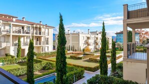 A residential complex with multiple apartment buildings, manicured gardens, and a swimming pool.